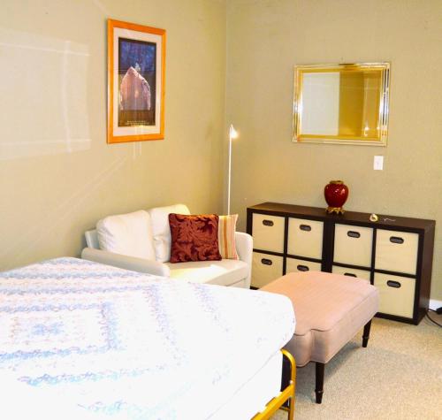a bedroom with a bed and a chair and a dresser at Cozy Nest Two Bedrooms in Grand Forks