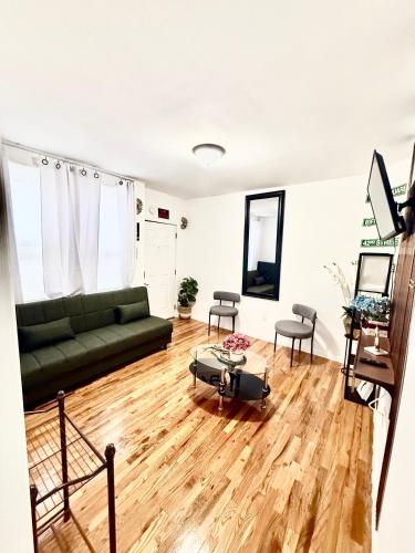a living room with a green couch and wooden floors at Apart Studio 12mint From New York City Times Square in West New York