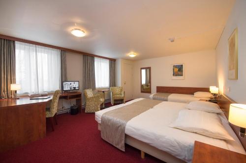 a hotel room with a large bed and a desk at Hotel Restaurant in den Hoof in Maastricht