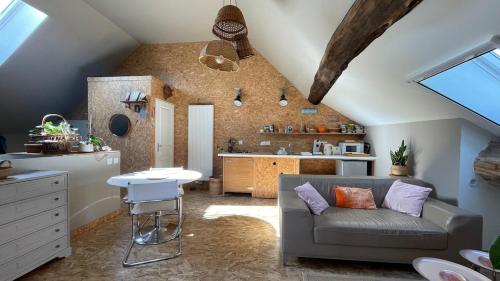 un salon avec un canapé et une cuisine dans l'établissement Au grenier du loup bleu, à Besain