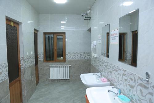 un baño con dos lavabos y dos espejos en Hostel Room, en Tashkent