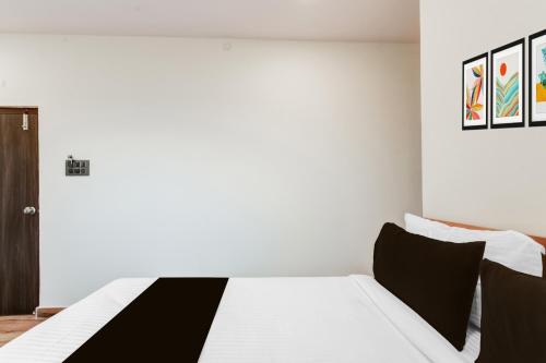 a white bedroom with a black and white bed at Hotel O Holiday Luxury in Hyderabad