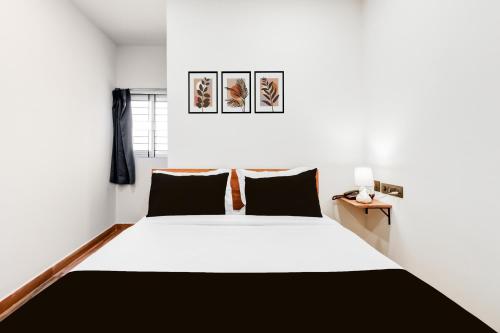 a bedroom with a large bed with black and white sheets at Hotel O Holiday Luxury in Hyderabad