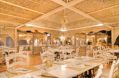 a dining room with white tables and white chairs at Domina Coral Bay Harem in Sharm El Sheikh