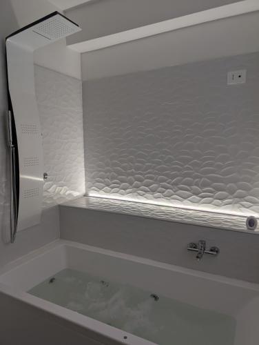 a bathroom with a bath tub with a sink at Infinity House Catania in Catania