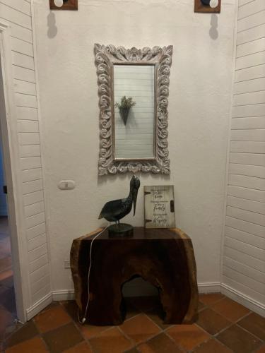 a statue of a bird sitting on a table in front of a mirror at Quinta Esencia in Brasilito
