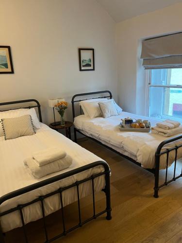 Granby Cottage, Peak District National Park في تيديسويل: سريرين يجلسون بجانب بعض في غرفة النوم