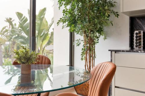 a glass table and chairs in a kitchen with plants at Ocean View Luxury Living in Carlsbad