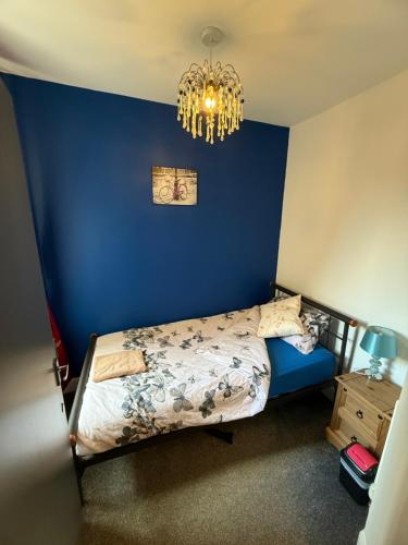 a bedroom with a blue wall and a bed at City Centre Modern 2 bedroom apartment in Perth