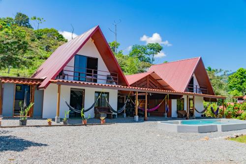a house with a red roof and a playground at Bongalows Chepe Araya in Pejibaye