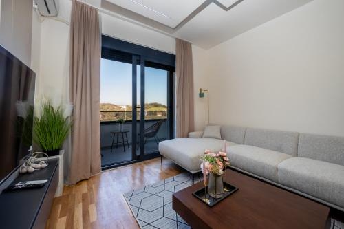 a living room with a couch and a tv at Cozy Coastal Bliss 1 in Ulcinj