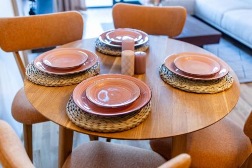 a wooden table with plates on top of it at Cozy Coastal Bliss 1 in Ulcinj