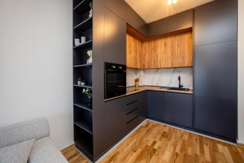 a kitchen with black cabinets and a counter at Cozy Coastal Bliss 1 in Ulcinj