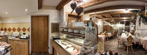 a restaurant with a dining room with tables and chairs at Hotel Garni San Nicolò in Pozza di Fassa