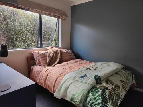 Un dormitorio con una cama con una ventana grande. en Ohakune Peak Retreat Unit 2, en Ohakune