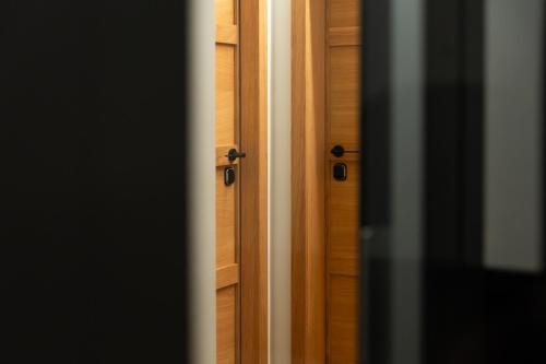 a wooden door with two handles on a wooden wall at Club64 in Andria