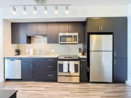 a kitchen with black cabinets and stainless steel appliances at Studio Downtown Walk to Convention Center in Los Angeles