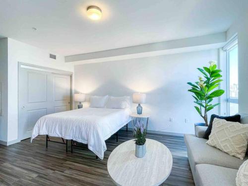 a bedroom with a bed and a couch and a table at Studio Downtown Walk to Convention Center in Los Angeles