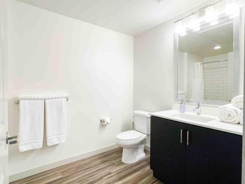 a white bathroom with a toilet and a sink at Studio Downtown Walk to Convention Center in Los Angeles