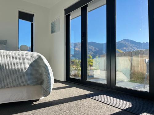ワナカにあるClearview Guest Studioのベッド1台、景色を望む窓が備わる客室です。