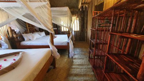 a room with two beds and a couple of bunk beds at Kirepwe Ecco Camp Watamu in Watamu