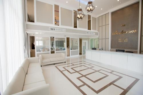 a store lobby with white furniture and a counter at The Bedroom Ladprao 101 Bangkok - SHA in Bangkok