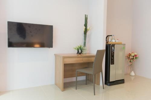 a room with a desk and a refrigerator and a chair at The Bedroom Ladprao 101 Bangkok - SHA in Bangkok