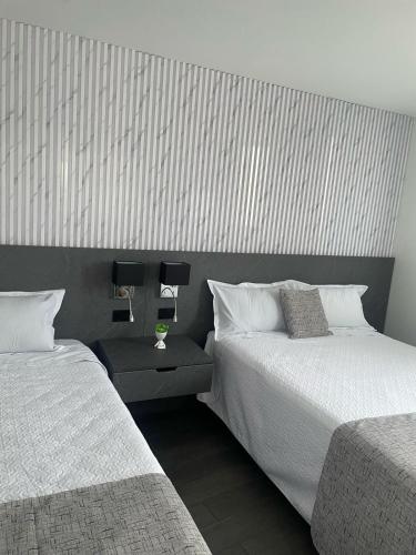 a bedroom with two beds and a wall with stripes at Casa de Bris in Arequipa