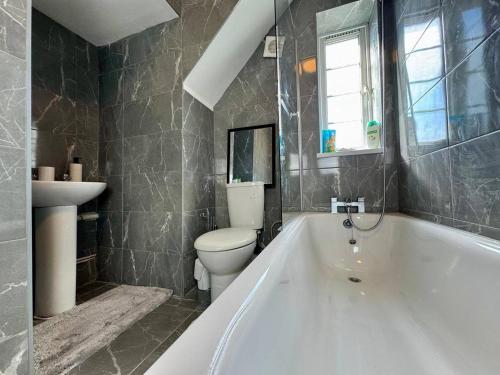 ロンドンにあるLuxury Flat by Tower Bridge, London - 2 Bedrooms, Free Parkingの浴槽、トイレ、洗面台を備えたバスルーム