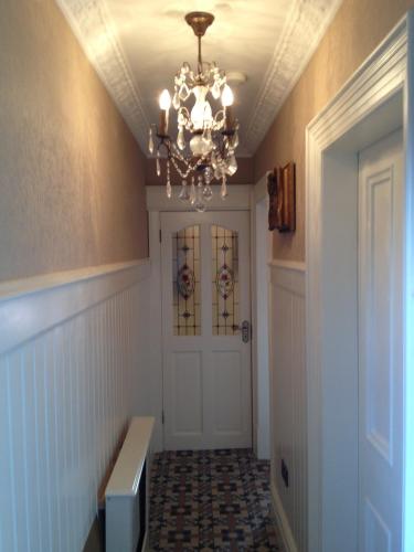 a hallway with a chandelier and a door at Riverside Lodge in Carlingford