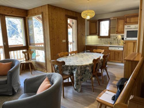 une cuisine avec une table et des chaises dans une pièce dans l'établissement Chalet L'alp Du Pontet - 4 pièces cabine 6 personnes exposé Sud-Ouest MAE-1391, à Valloire