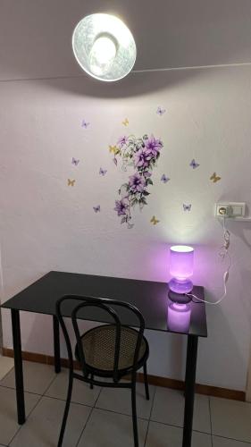 a table with a lamp and butterflies on a wall at Le Signoret in Sault-de-Vaucluse