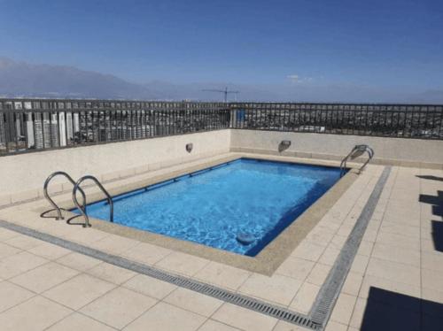 a swimming pool on the roof of a building at Full Equipado a pasos Metro Ecuador in Santiago