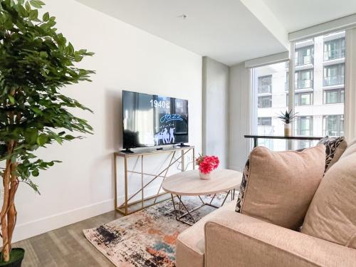 a living room with a couch and a tv at Suite Downtown Pool and Gym Access in Los Angeles