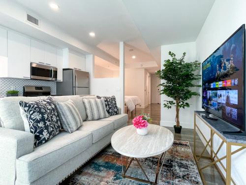a living room with a couch and a tv at Suite Downtown Pool and Gym Access in Los Angeles