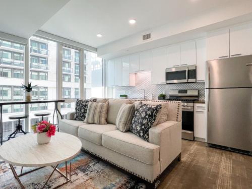 a living room with a couch and a kitchen at Suite Downtown Pool and Gym Access in Los Angeles