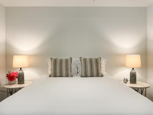 une chambre avec un grand lit blanc avec deux lampes dans l'établissement Suite Downtown Pool and Gym Access, à Los Angeles