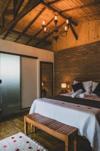 a bedroom with a large bed and a wooden ceiling at Chalé pinheirinho in Itamonte