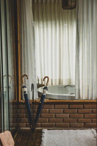two umbrellas sitting in front of a window at Chalé pinheirinho in Itamonte
