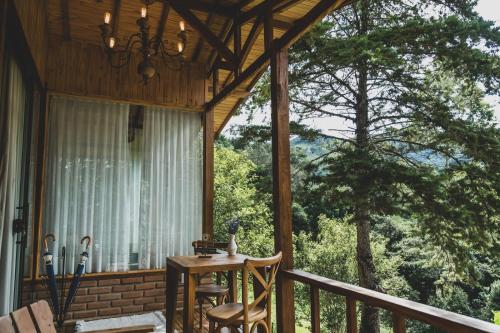 a screened in porch with a table and chairs at Chalé pinheirinho in Itamonte