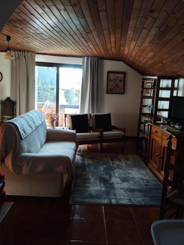 a living room with a couch and a window at ABRIGO DO CABECINHO - SERRA DA ESTRELA in Cortes do Meio
