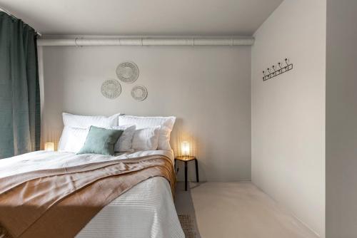 a white bedroom with a bed and two plates on the wall at Newly renovated apartment by the sea in Hafnarfjörður in Hafnarfjördur