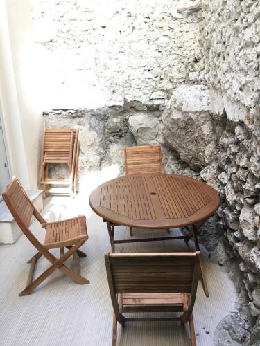 une table et des chaises devant un mur de pierre dans l'établissement Safranier Townhouse, à Antibes