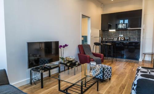 a living room with a couch and a table at Bordeaux Traditions in Bordeaux