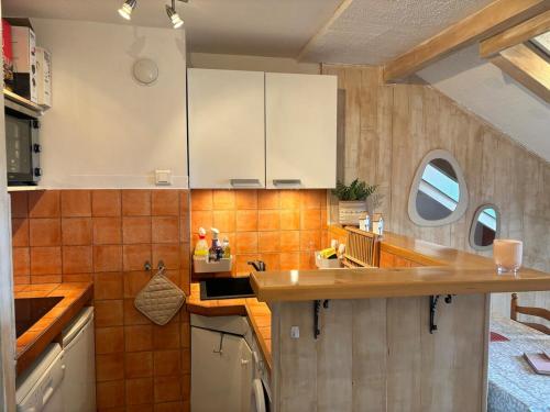 - une cuisine avec des placards blancs et du carrelage orange dans l'établissement Appartement au pied des pistes, à Saint-Léger-les-Mélèzes