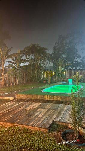 a swimming pool in a backyard with a green yard at Quarto Recanto Monte Trigo in São Francisco do Sul