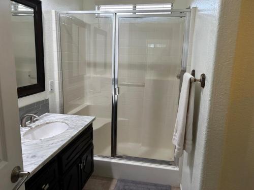 a bathroom with a shower with a sink and a mirror at Walking Distance to Stagecoach in Indio