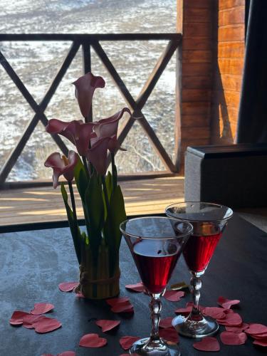a table with two glasses and a vase with flowers at Old Byurakan Gouest House in Byurakan