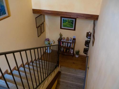 a hallway with a staircase with wooden floors and a stair railing at Il poggio degli antichi sapori in Paternopoli