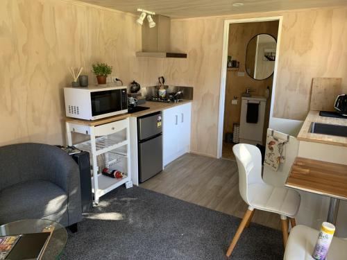 a small kitchen with a couch and a microwave at Herbert Hampden Cottage in Herbert